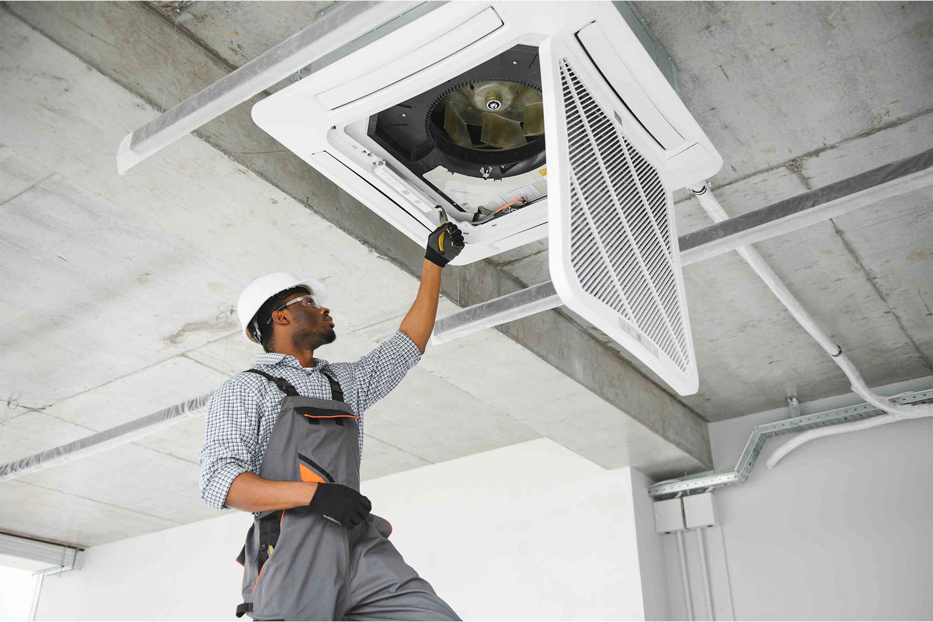 HVAC technician servicing a ceiling-mounted unit